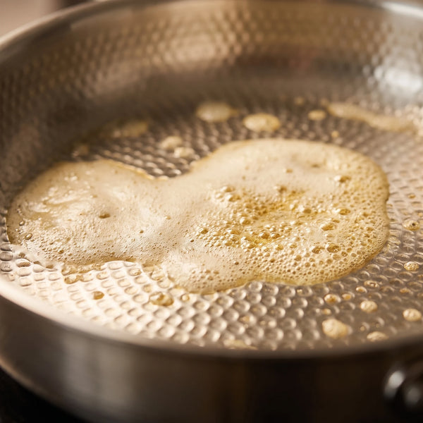 Butter melting across the hammered surface before the eggs go in